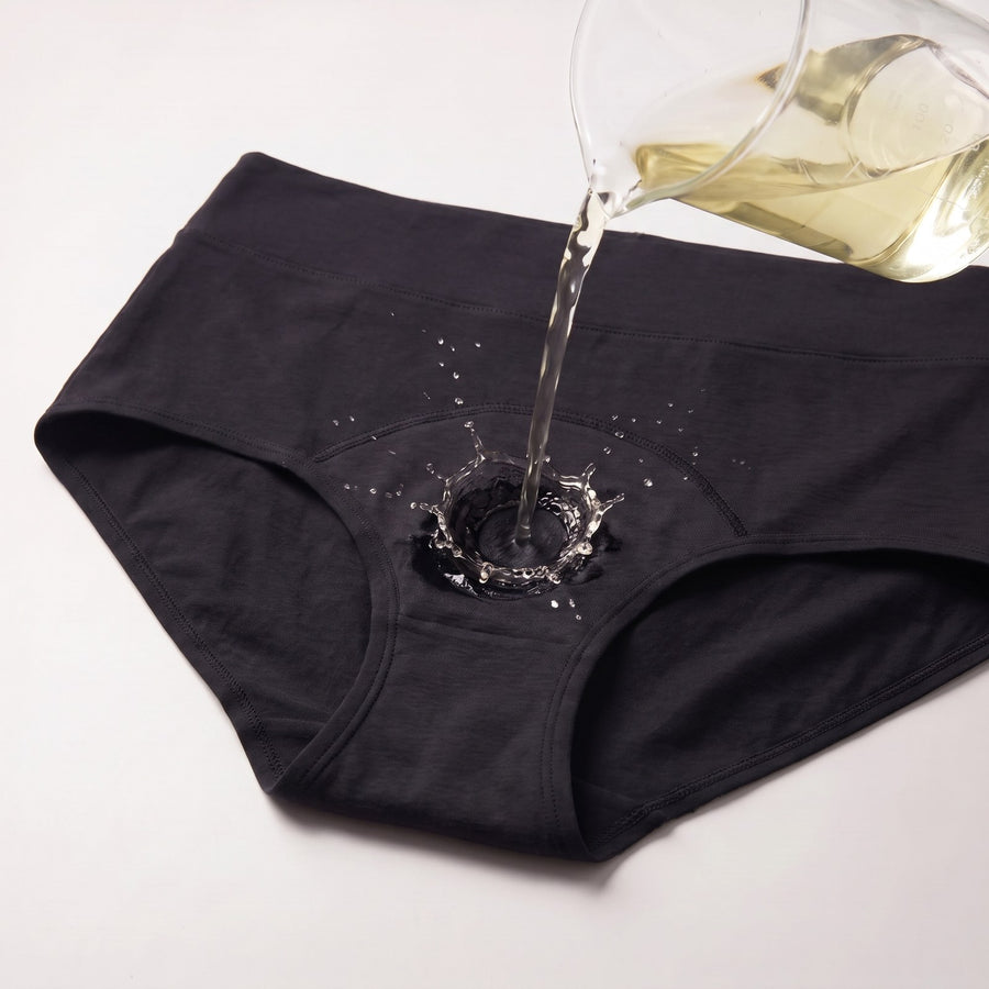 Test di assorbenza: liquido versato sul tassello assorbente dello slip lavabile Fresia nero a vita alta