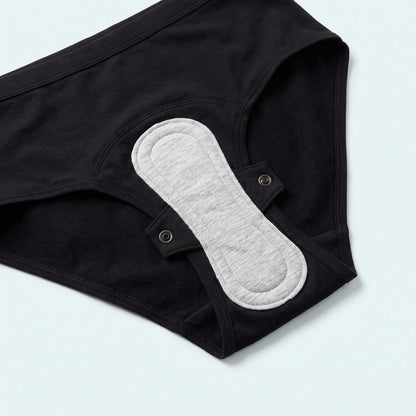 Interno dello slip nero: fondo assorbente e assorbente lavabile agganciato con 2 bottoni a pressione